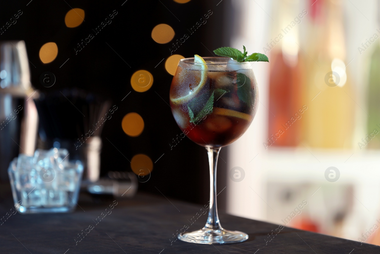 Photo of Fresh alcoholic cocktail with lemon and mint on bar counter