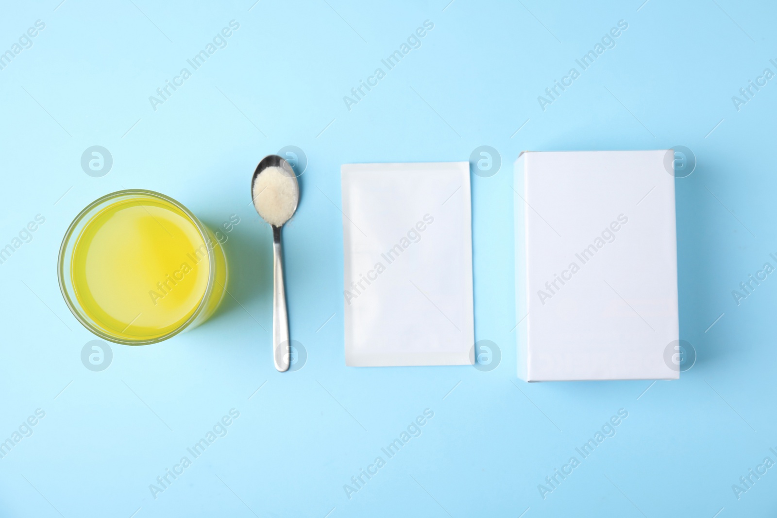 Photo of Box, sachet, spoon and glass of dissolved medicine on turquoise background, flat lay