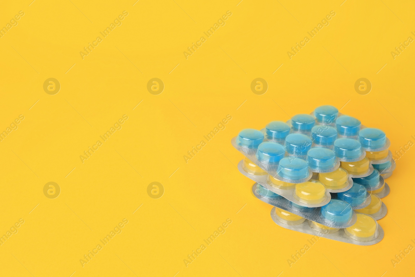 Photo of Blisters with cough drops on yellow background. Space for text