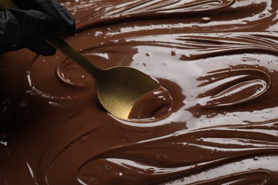 Photo of Person making tasty milk chocolate paste, closeup