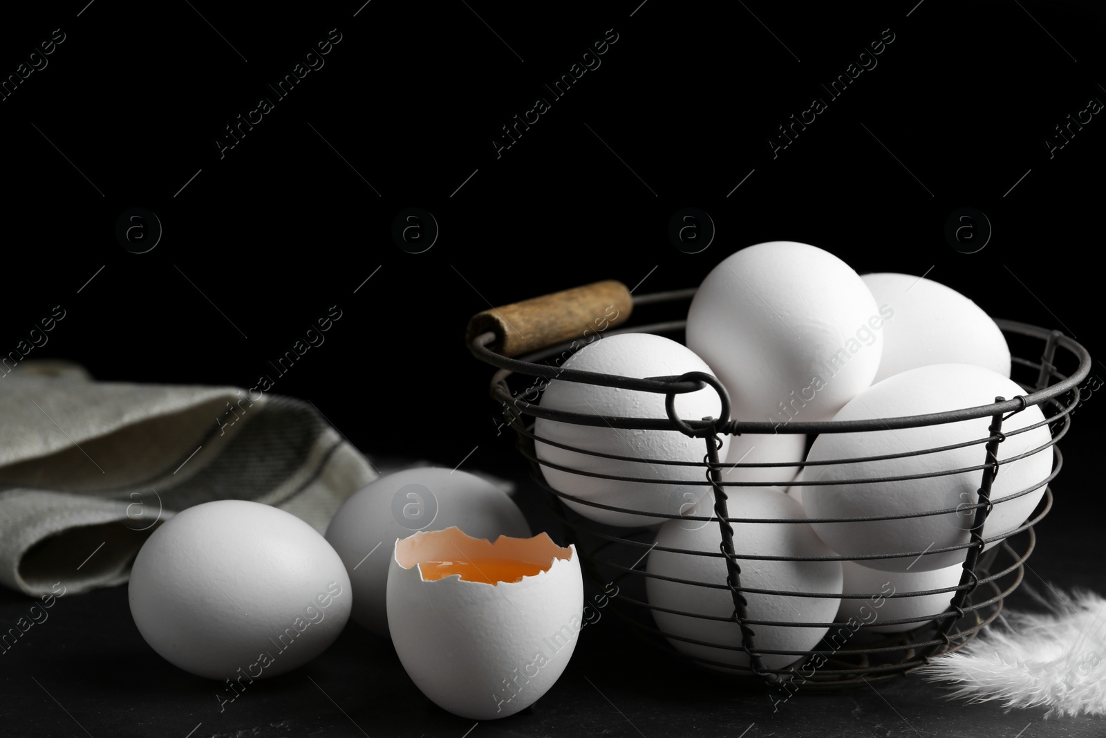 Photo of Composition with fresh raw chicken eggs on black table