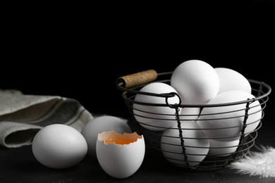 Photo of Composition with fresh raw chicken eggs on black table