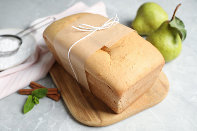 Photo of Tasty tied pear bread on light table, closeup. Homemade cake