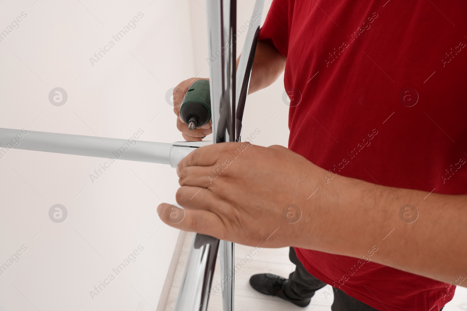 Photo of Worker installing new metal pipes with electric drill, closeup