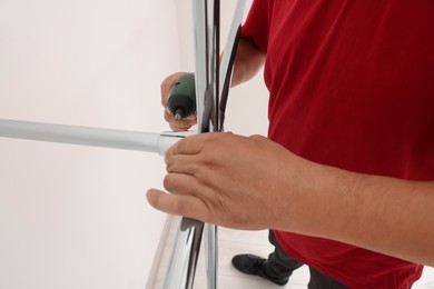 Worker installing new metal pipes with electric drill, closeup