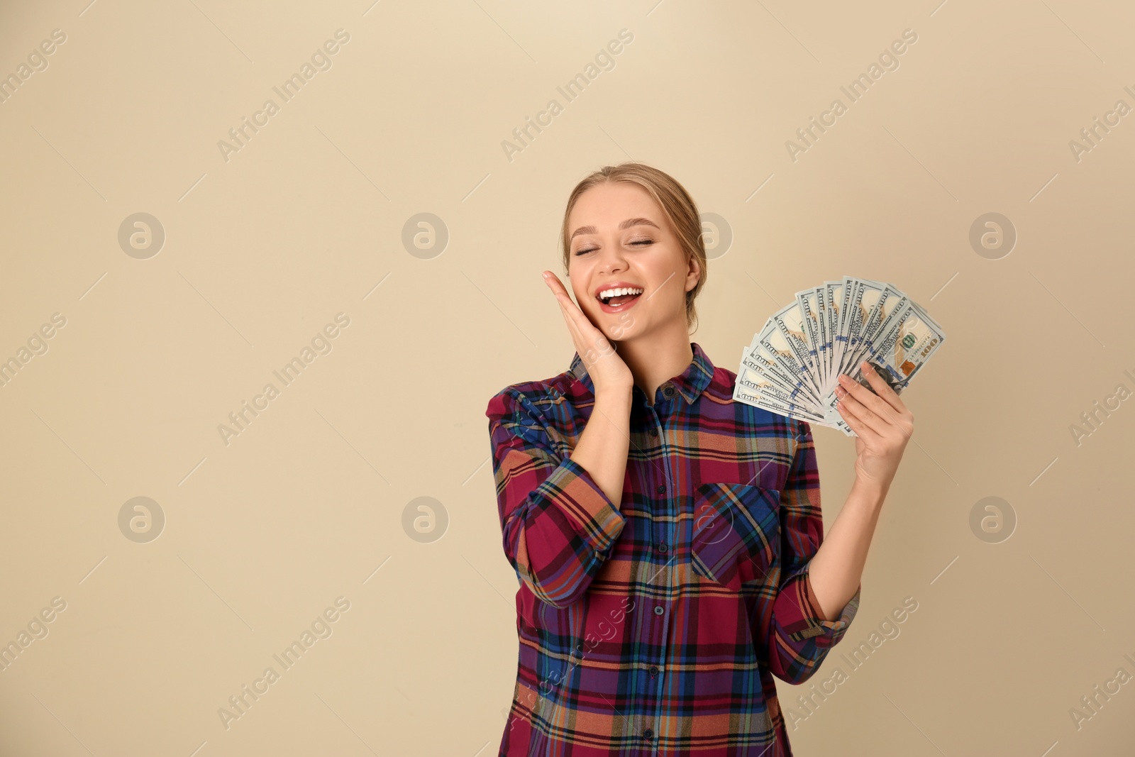 Photo of Portrait of happy young woman with money on color background. Space for text