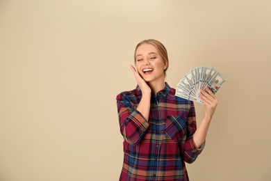 Portrait of happy young woman with money on color background. Space for text