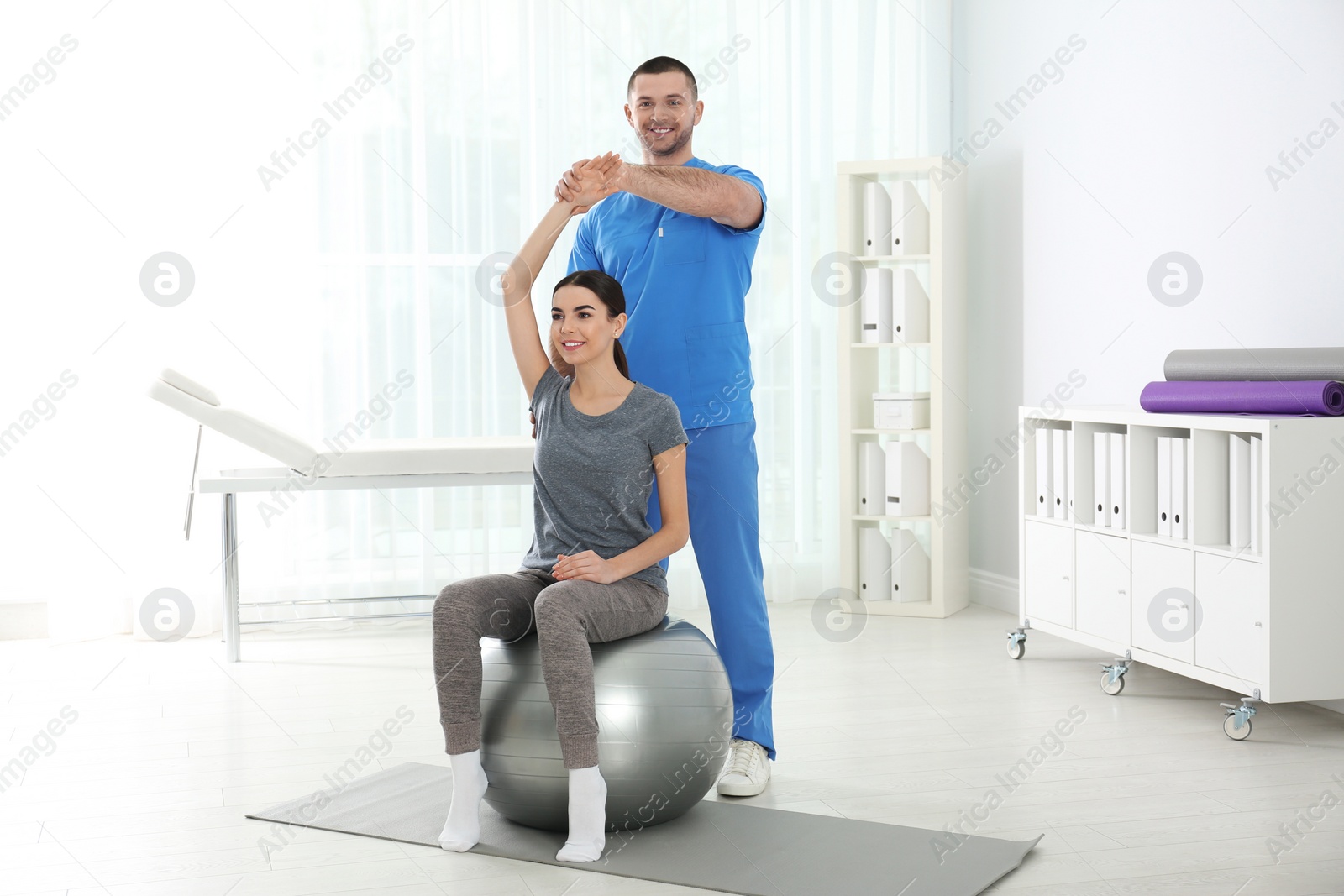 Photo of Doctor working with patient in hospital. Rehabilitation exercises