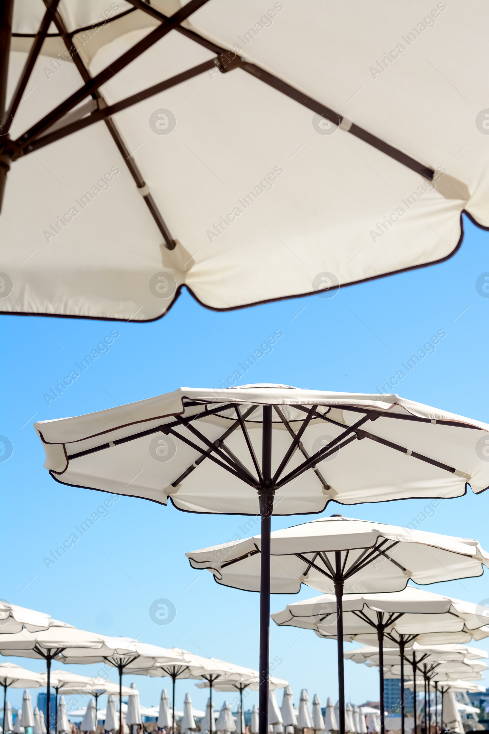 Photo of Beautiful white beach umbrellas against blue sky