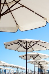 Beautiful white beach umbrellas against blue sky