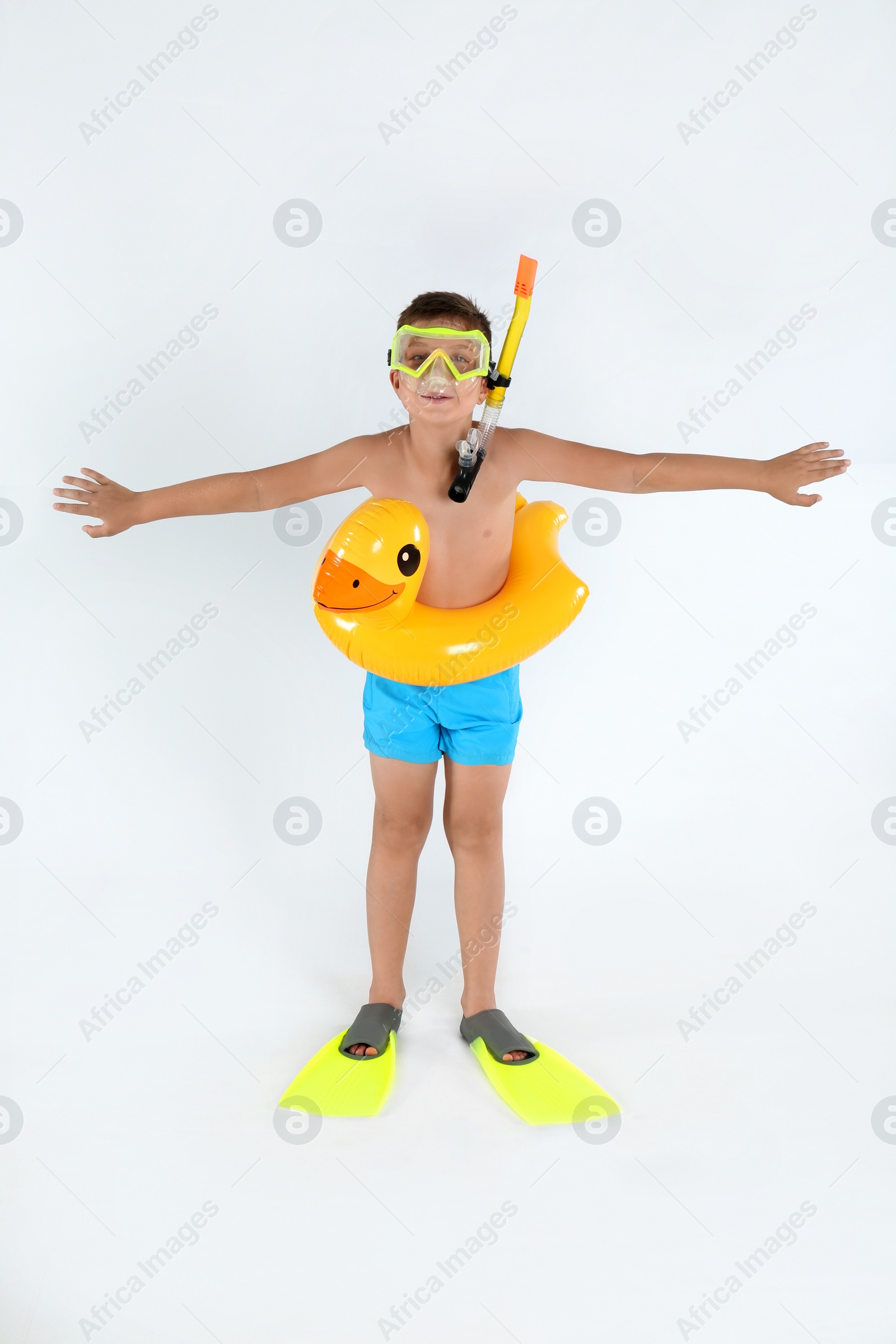 Photo of Cute little child in beachwear with bright inflatable ring on white background