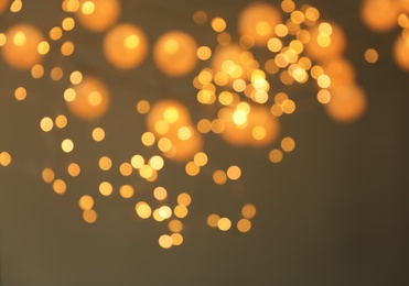 Photo of Blurred view of gold lights on dark background. Bokeh effect