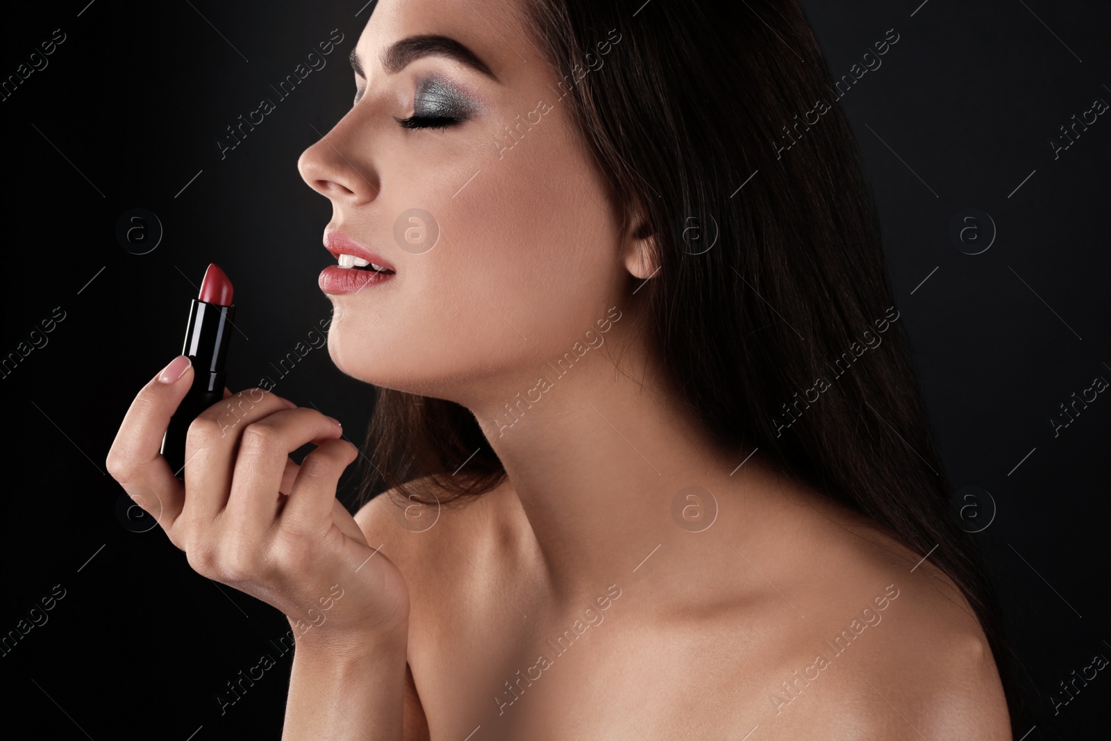 Photo of Portrait of beautiful woman with lipstick on dark background. Stylish makeup