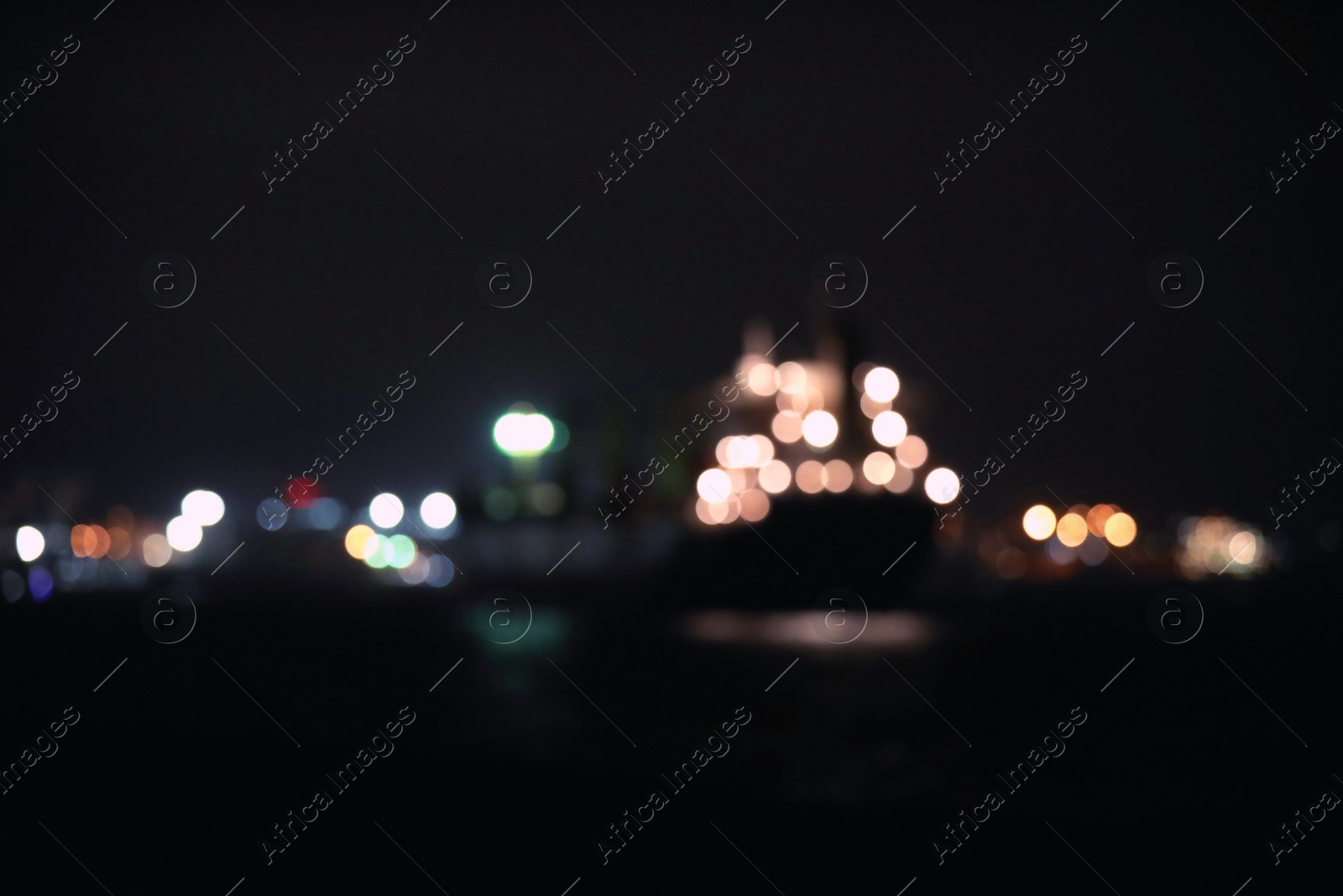 Photo of Blurred view of bulk carrier in roads at night. Bokeh effect