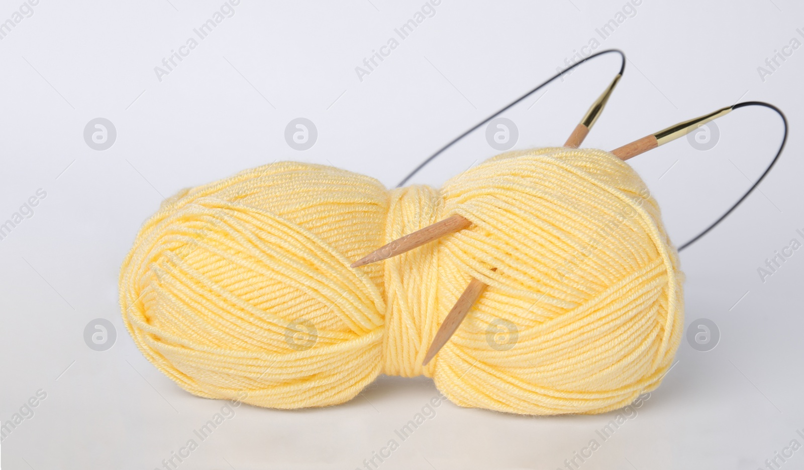 Photo of Soft woolen yarn and knitting needles on white background