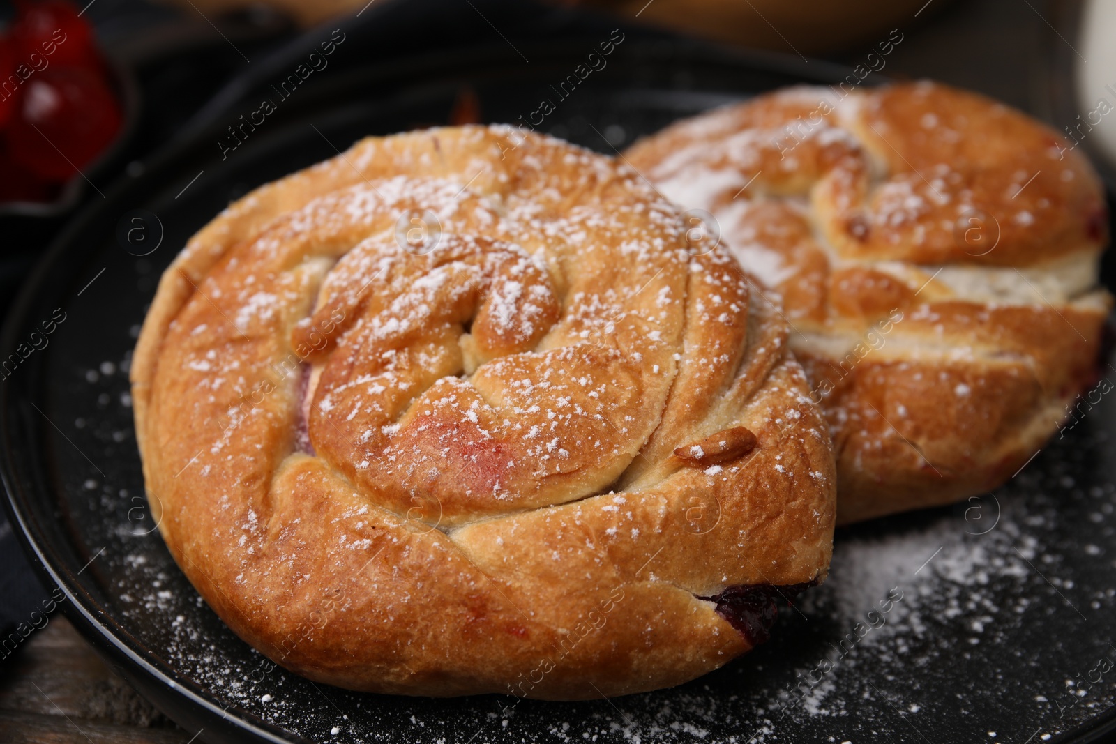 Photo of Delicious rolls with sugar powder on table, closeup. Sweet buns