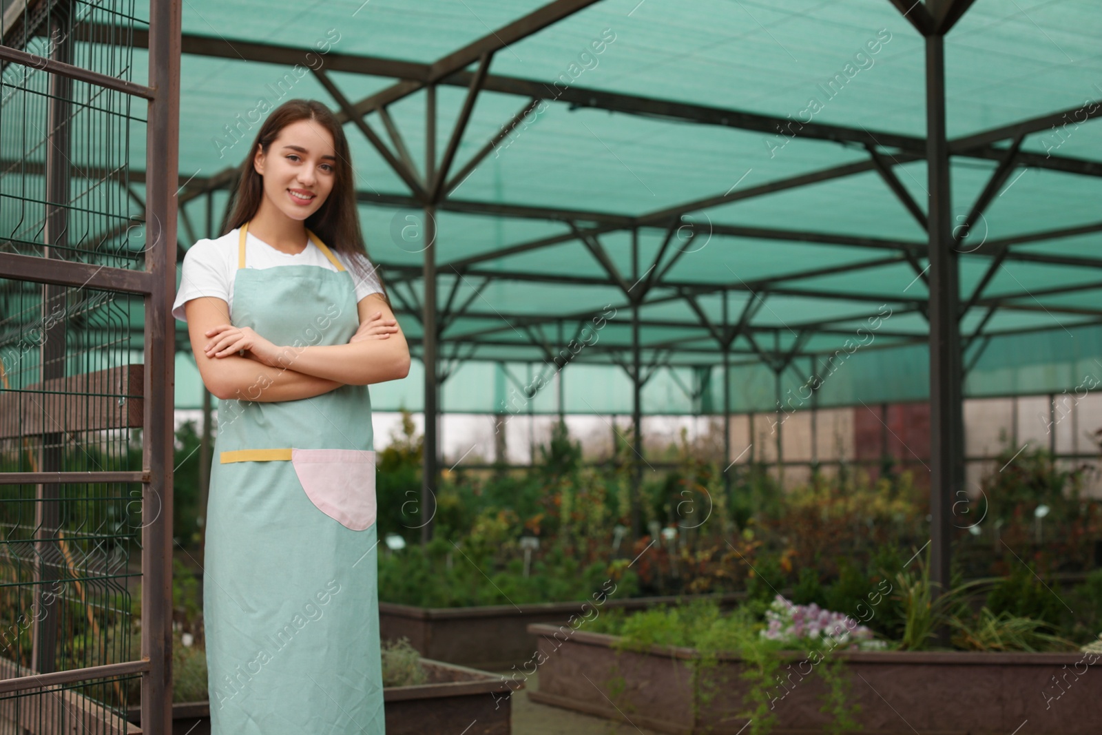 Photo of Female business owner in greenhouse. Space for text