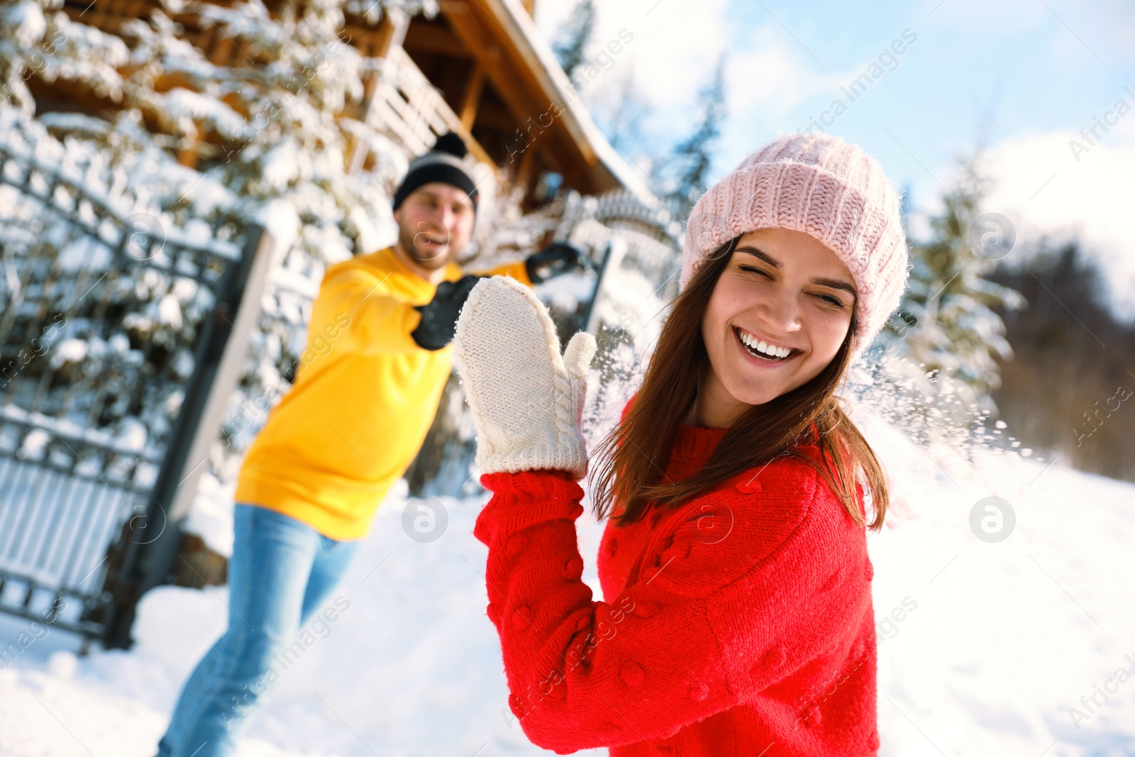 Photo of Happy couple playing snowballs outdoors. Winter vacation