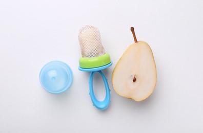 Photo of Nibbler with fresh pear on white background, flat lay. Baby feeder