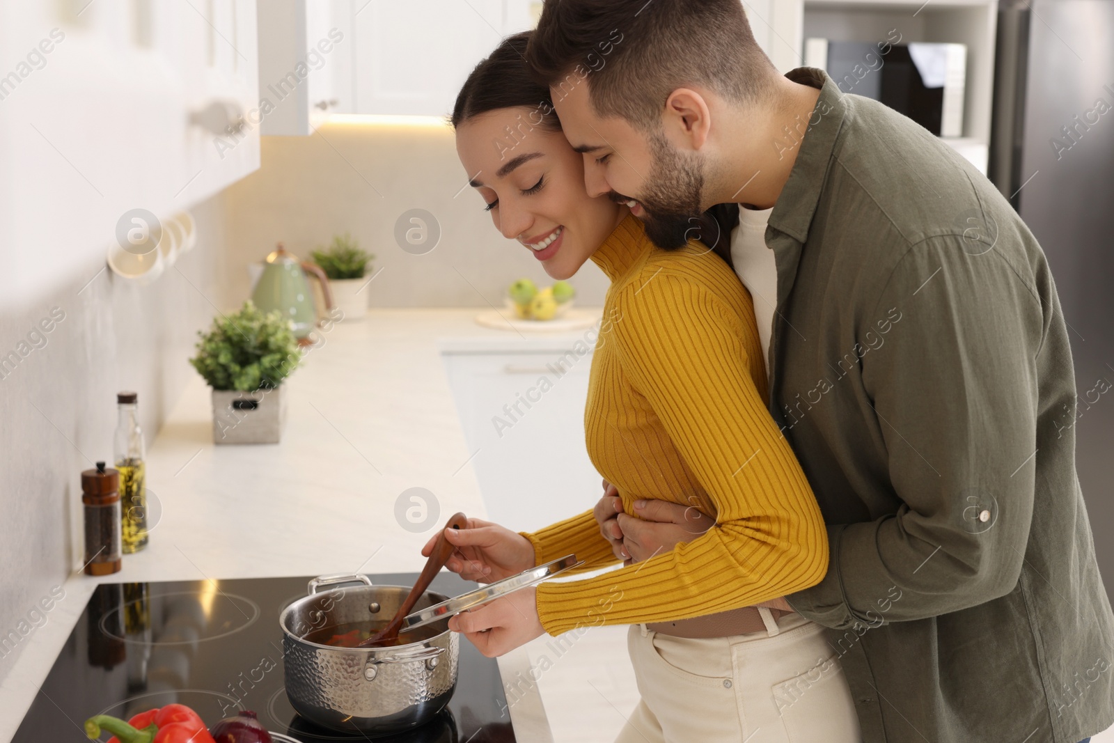 Photo of Lovely couple enjoying time together while cooking in kitchen