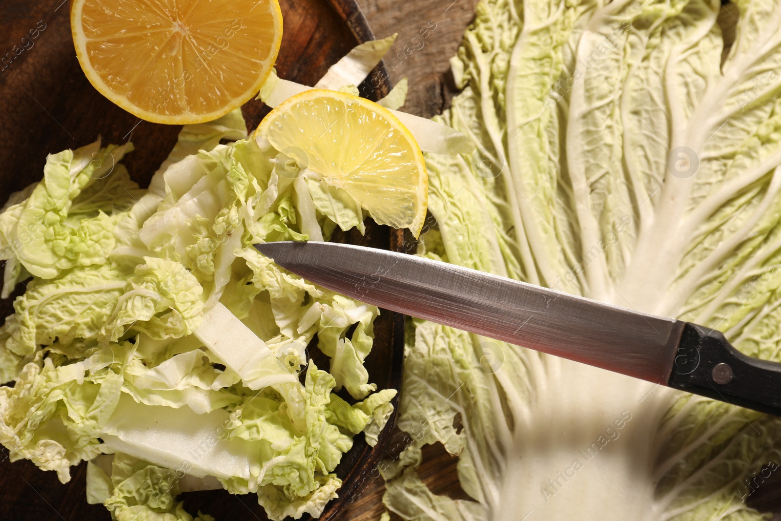 Photo of Fresh Chinese cabbage, lemon and knife on table, top view