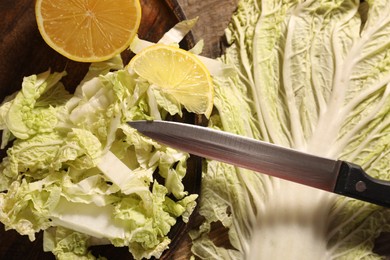 Fresh Chinese cabbage, lemon and knife on table, top view