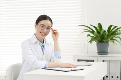 Medical consultant with glasses at table in clinic