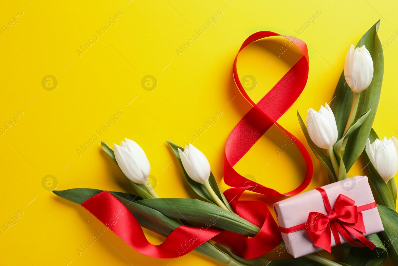 Photo of 8 March card design with tulips, gift and space for text on yellow background, flat lay. International Women's Day