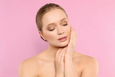 Photo of Portrait of young woman with beautiful face on pink background