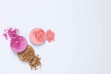 Different crushed eye shadows on white background, flat lay. Space for text