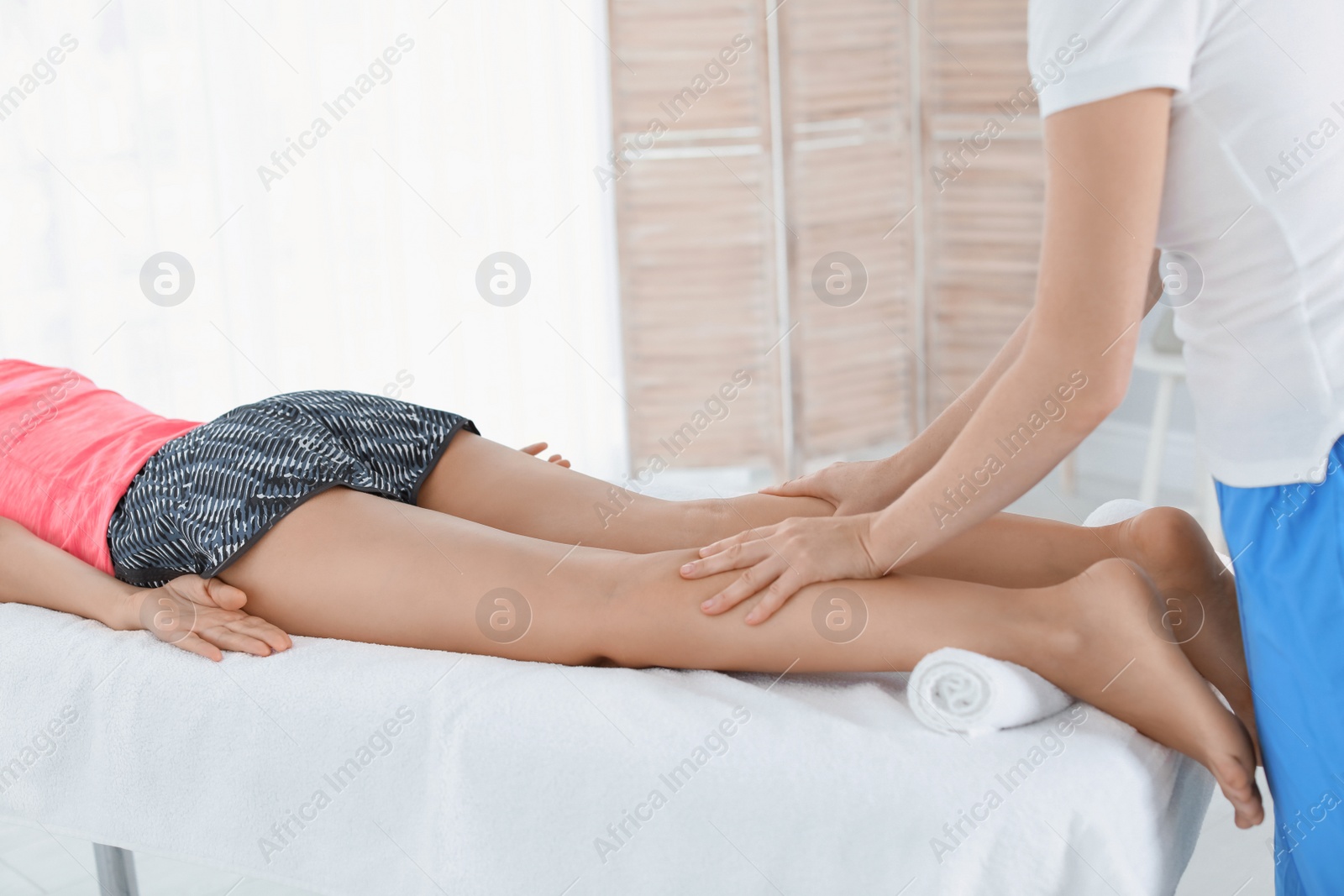 Photo of Woman receiving leg massage in wellness center