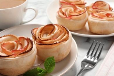 Freshly baked apple roses served on white marble table. Beautiful dessert