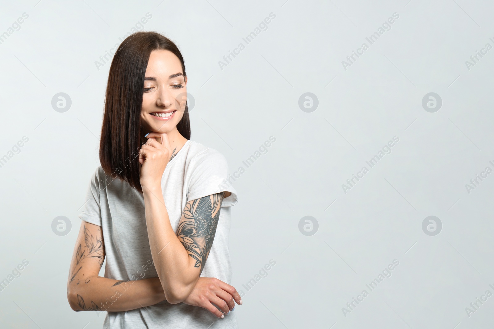 Photo of Portrait of pretty young woman with gorgeous chestnut hair and charming smile on light background, space for text