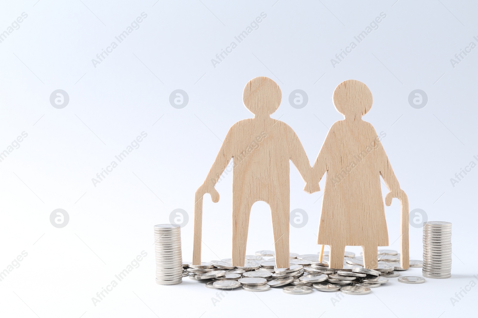 Photo of Pension savings. Figure of senior couple and coins on white background, space for text