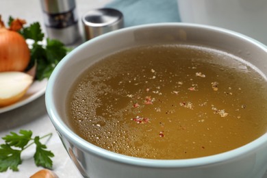 Photo of Hot delicious bouillon in cup on table, closeup