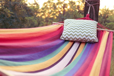 Photo of Comfortable bright hammock with soft pillow at green garden, closeup
