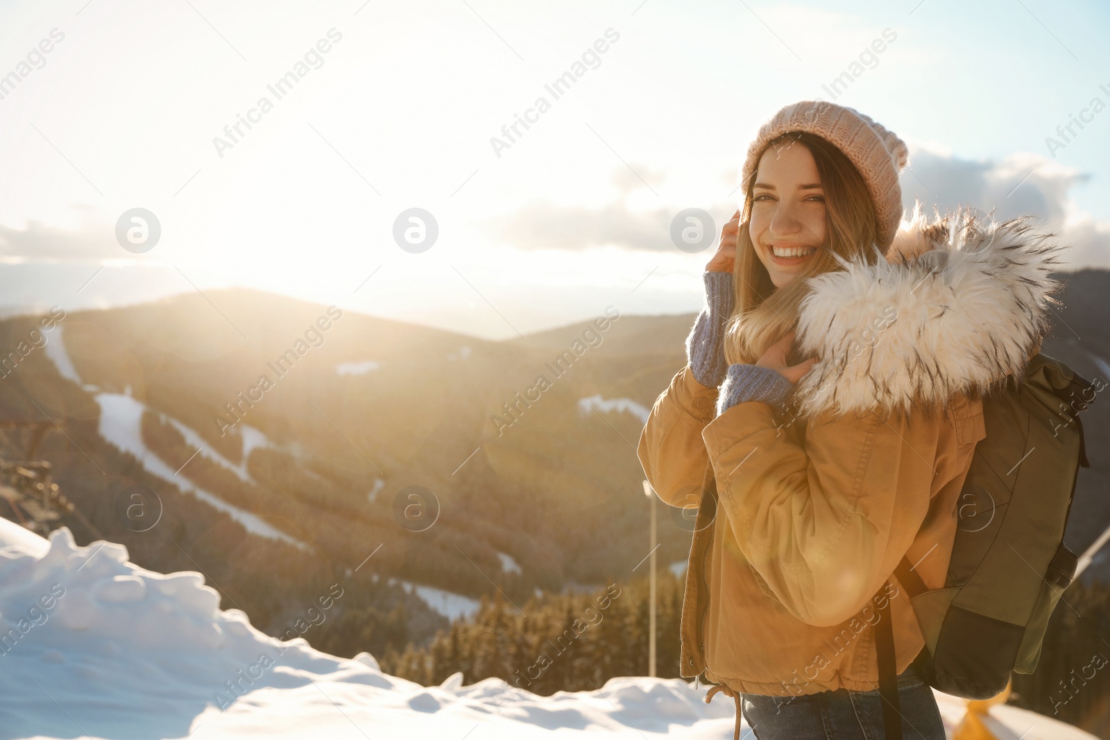 Photo of Happy young woman spending winter vacation in mountains. Space for text