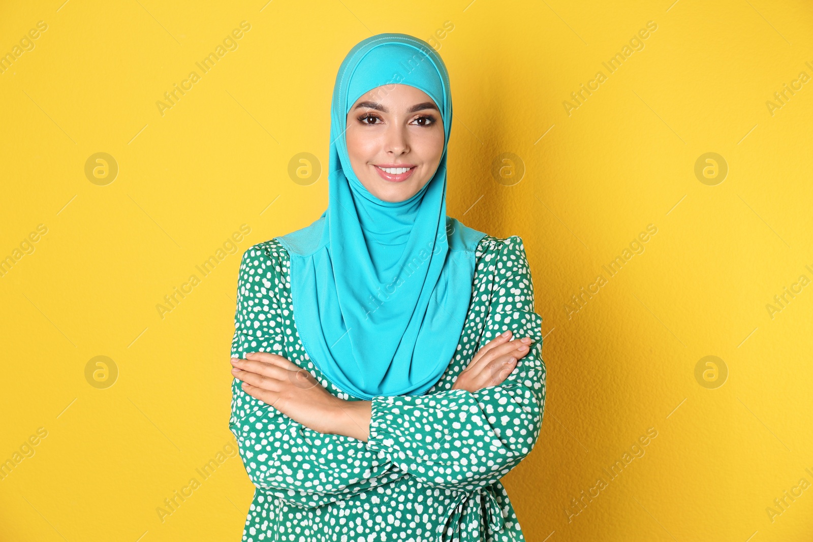 Photo of Portrait of young Muslim woman in hijab against color background