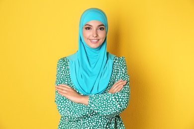 Photo of Portrait of young Muslim woman in hijab against color background