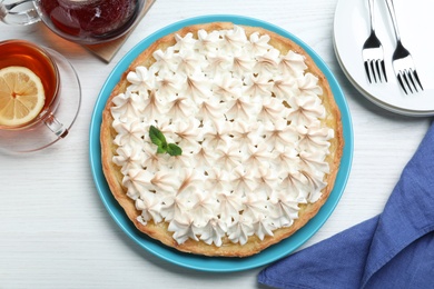 Flat lay composition with delicious lemon meringue pie on white wooden table