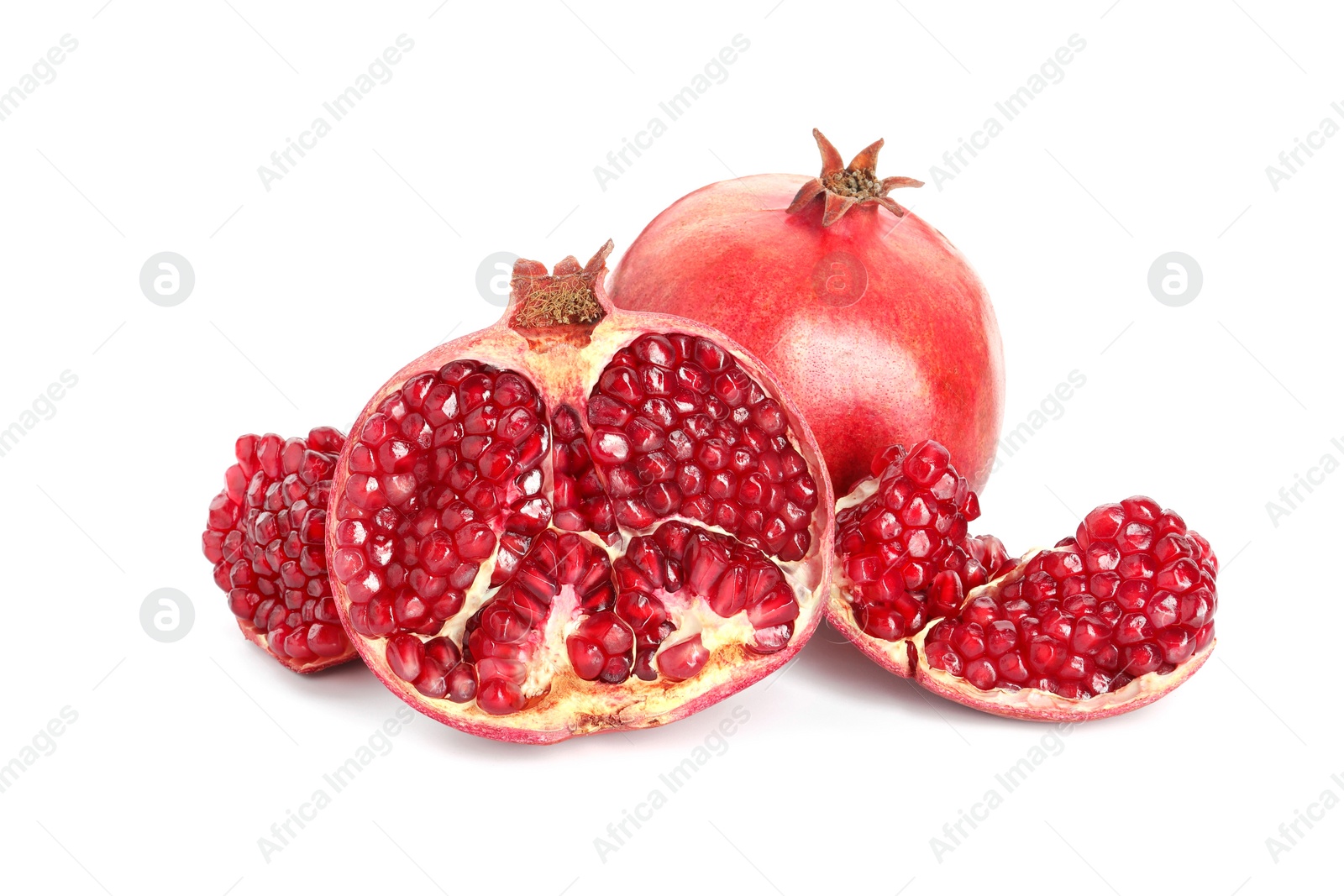 Photo of Cut and whole pomegranates isolated on white