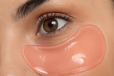 Photo of Young woman with pink under eye patch, closeup