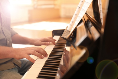 Photo of Man playing piano indoors, closeup. Music lesson