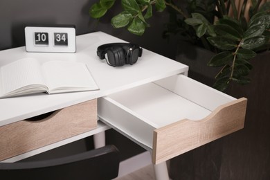 Stylish desk with open empty drawer in office