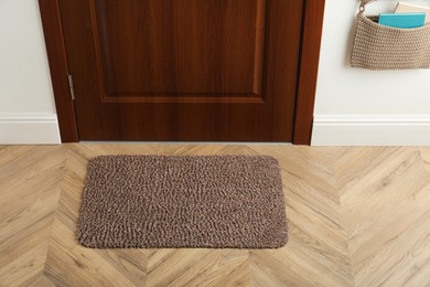 Clean door mat on wooden floor in hall