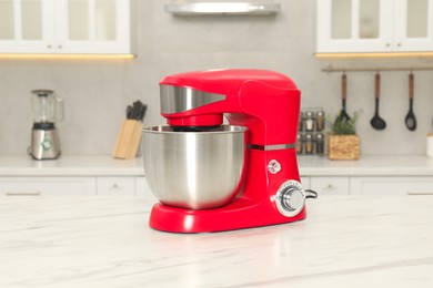 Photo of Modern red stand mixer on white marble table in kitchen