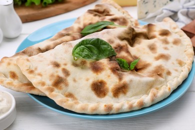 Photo of Delicious cheese calzones on white wooden table, closeup
