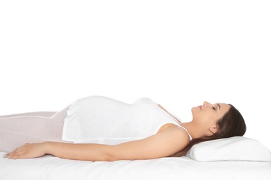 Photo of Beautiful pregnant woman sleeping with orthopedic pillow on bed against white background