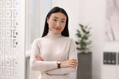 Photo of Portrait of beautiful businesswoman with crossed arms in office