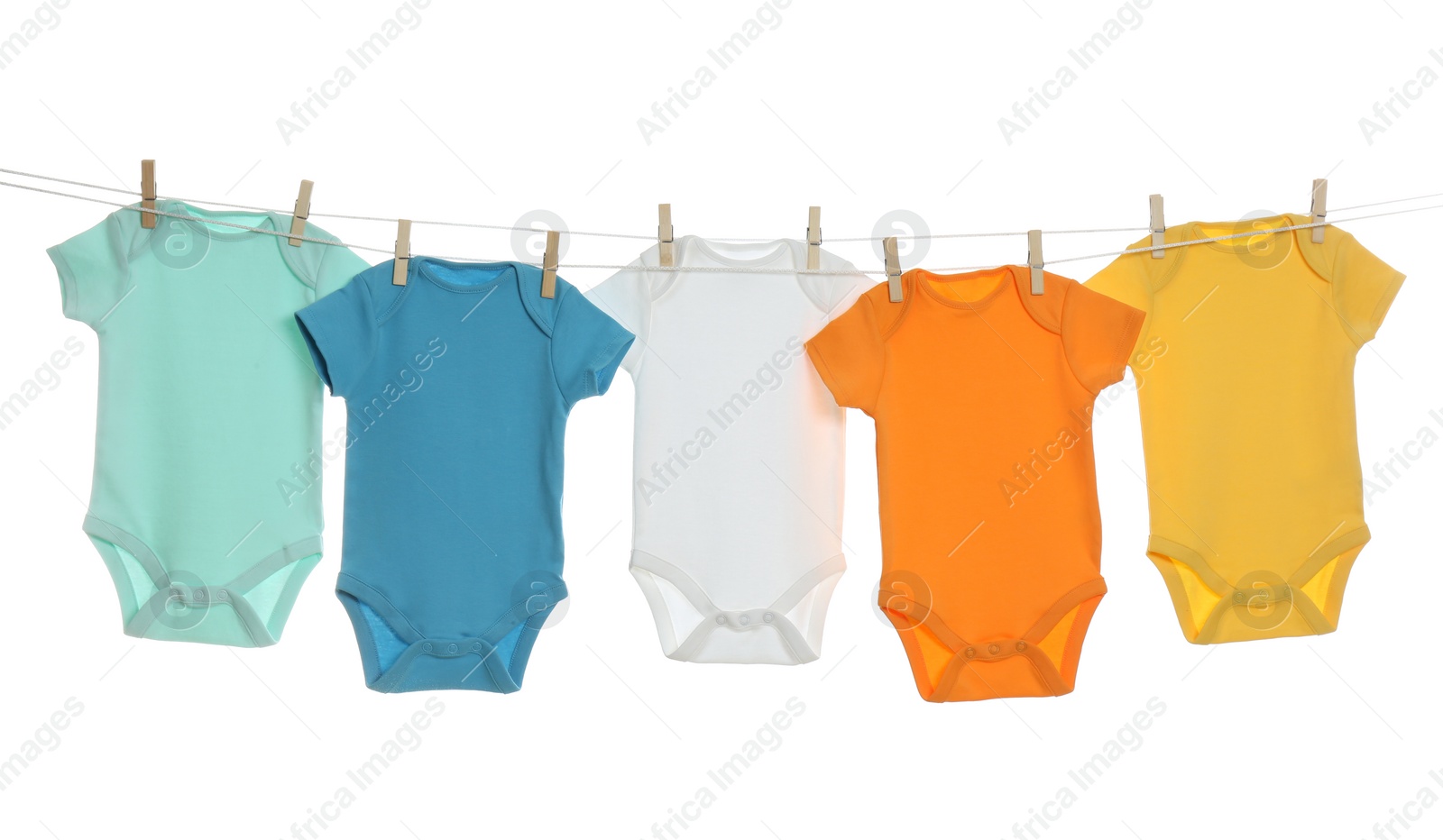 Photo of Colorful baby onesies hanging on clothes line against white background. Laundry day